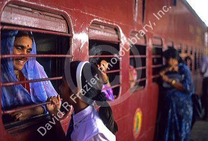Indian woman and daughter talk through window of a train at station in Mumbai, India.
