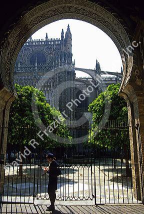View of the Cathedral through an arched gate of the Alcazar of Seville, Spain.