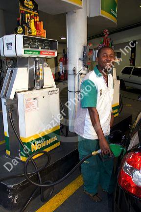 Attendant at a gas station pumping alcohol into a car in Sao Paulo, Brazil.