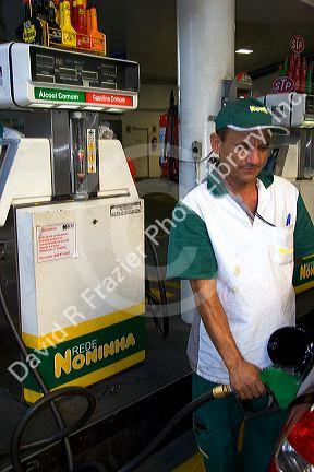 Attendant at a gas station pumping alcohol into a car in Sao Paulo, Brazil.