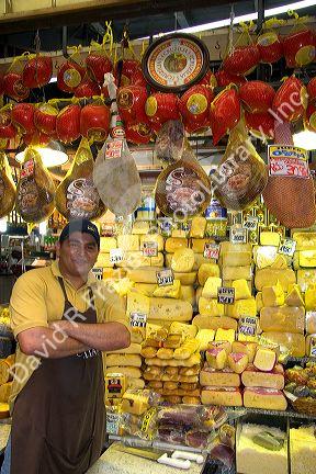 Merchant selling a variety of cheese at the Mercado Municipal in Sao Paulo, Brazil.