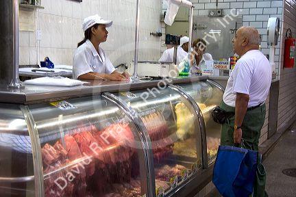 Man shopping for meat at the Mercado Municipal in Sao Paulo, Brazil.