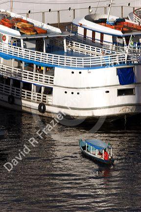 Water taxi among amazon river boats at sunrise in Manaus, Brazil.