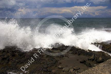 Waves crash on rocks on the island of Tahiti.