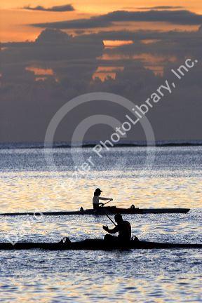 Outrigger canoeing at sunset off the island of Tahiti.