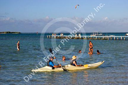 People swimming and kayaking in the lagoon at the Tipaniers Hotel on the island of Moorea.