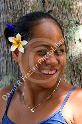 Tahitian woman wearing a plumeria flower in her hair on the island of Moorea.