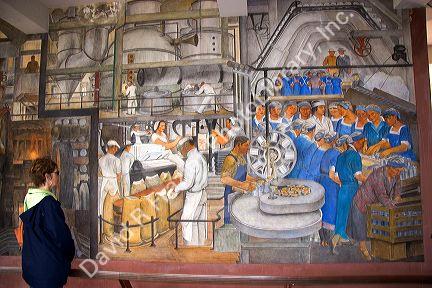 Woman viewing a mural in the interior of the Coit Tower at San Francisco, California.