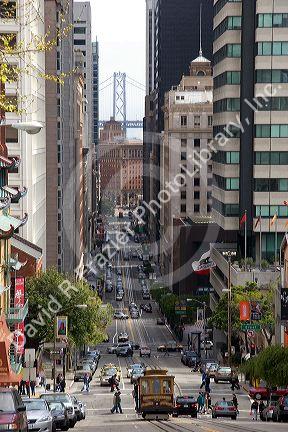 California Street scene with traffic and cable car in San Francisco, California. Bay Bridge tower in background.