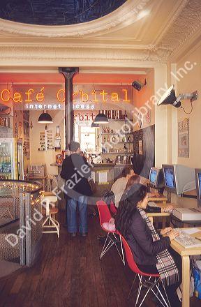 People using computers in an internet cafe.  Paris, France.