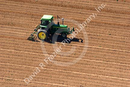 Aerial view of a farmer on a tractor spring tilling a field in Canyon County, Idaho.