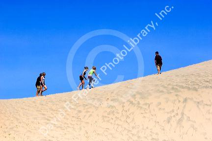 People walk on sand dunes at Pacific City on the Oregon Coast.