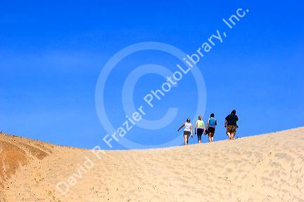 People walking on sand dunes at Pacific City on the Oregon Coast.