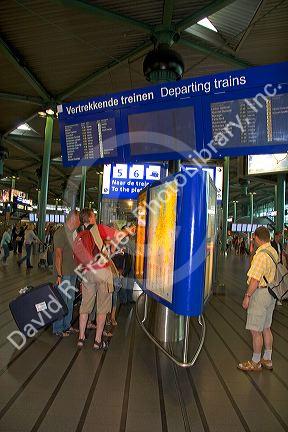 People buy tickets for the train in the terminal at Schiphol Airport in Amsterdam, Netherlands.