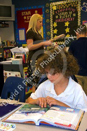 Fourth grade student reading a textbook in a classroom at a public school in Tampa, Florida.