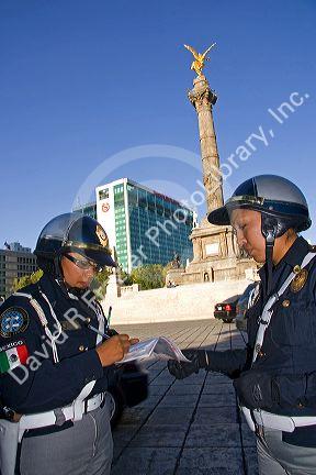 Female police officers write a traffic ticket in front of El Angel de la Independencia in Mexico City, Mexico.