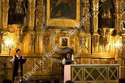 A priest performs mass in front of a gold alter inside the Catedral Metropolitana located on the central square, the zocalo, Mexico.