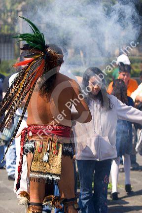 Aztec indian in traditional dress performing a spiritual ceremony with smoke on the Day of the Dead in Mexico City, Mexico.