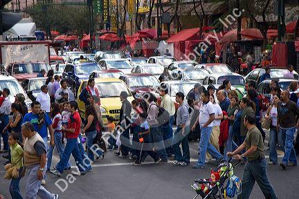 Pedestrians cross the street in front of heavy traffic at the intersection of Paseo de la Reforma and Eje Central Lazaro Cardenas in Mexico City, Mexico.