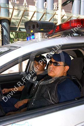 Mexican police officers sit in a police car with a remote camera on the roof which transmits real time images to a command center in Mexico City, Mexico.