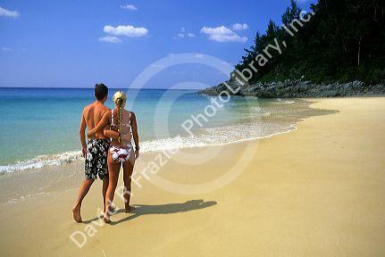 A couple walking on Nai Yang beach on Phuket Island, Thailand.