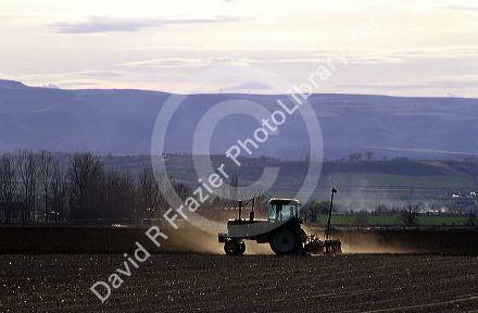 Tractor tilling soil.