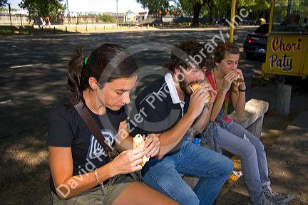 People eat chorizo sandwiches along the Rio de la Plata in Buenos Aires, Argentina.