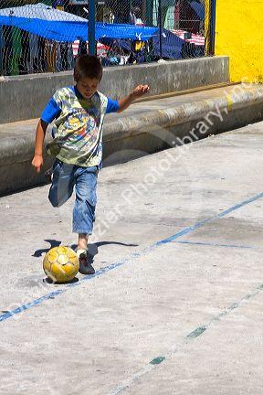 Young boy playing with a soccer ball in the La Boca barrio of Buenos Aires, Argentina.