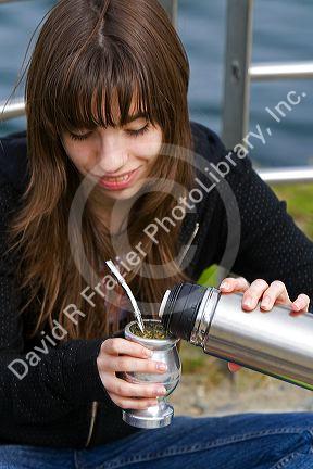 Girl making a mate drink at Ushuaia on the island of Tierra del Fuego, Argentina.