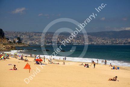 Beach scene in Renaca on the Pacific Ocean in Chile with Vina del Mar and Valparaiso in the background.