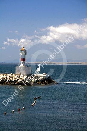 Small lighthouse and sailboat on the Pacific Ocean at Concon, Chile.