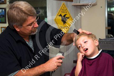Barber giving a three year old boy a haircut in Tampa, Florida. MR