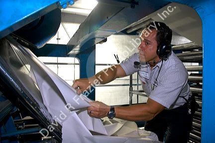 Worker clearing a torn web from the rotary printing press at the Houston Chronicle in Houston, Texas.