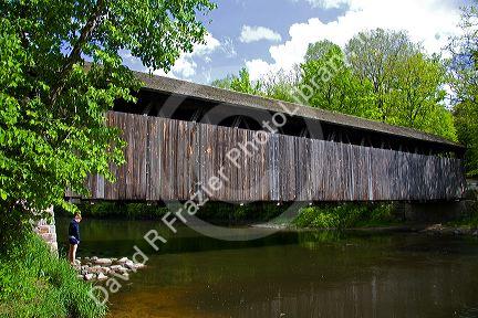 Whites Bridge, a brown truss covered bridge spanning the Flat River in Keene Township, Michigan.