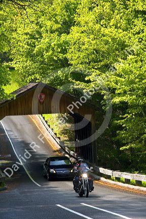 Vehicles driving through a covered bridge in the Sleeping Bear Dunes National Lakeshore located along the northwest coast of the Lower Peninsula of Michigan.