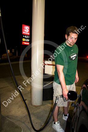 Gas prices displayed behind a man pumping gas in Lansing, Michigan on May 31, 2008.