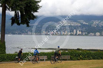 Bicyclists ride along the Seawall path in Staney Park at Vancouver, British Columbia, Canada.