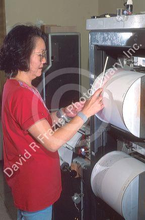 Asian woman using a seismograph at Volcano National Park on Big Island, Hawaii.