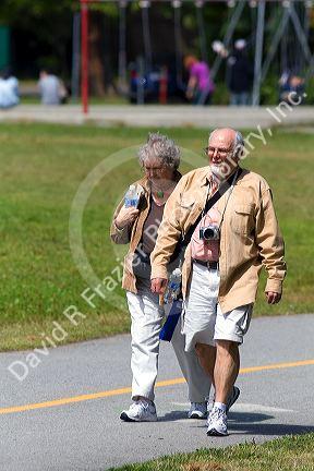 Tourists walk along the Seawall path in Stanley Park at Vancouver, British Columbia, Canada.