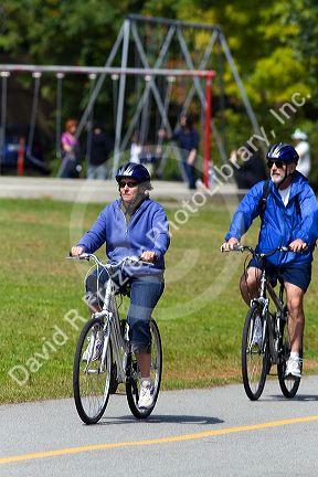 Bicyclists ride along the Seawall path in Stanley Park at Vancouver, British Columbia, Canada.
