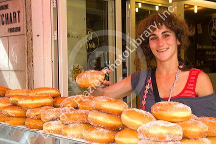 Woman selling beignets in the town of Saint-Jean-de-Luz, Pyrenees-Atlantiques, French Basque Country, Southwest France.