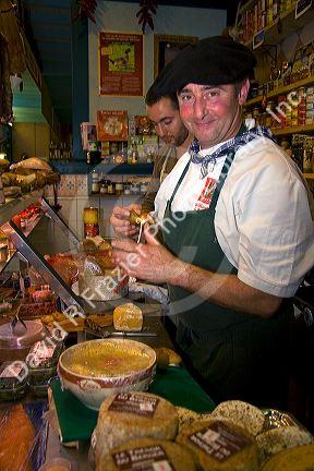 French Basque men working in a shop that sells cheese and meats in the town of Saint-Jean-de-Luz, Pyrenees Atlantiques, French Basque Country, Southwest France.