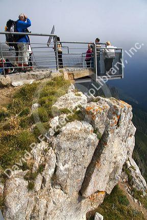 Visitors stand on a platform overlooking the Picos de Europa at Fuente De, Liebana, Cantabria, northwestern Spain.