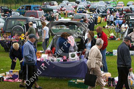 People buy and sell household items at a car boot sale in the market town of Banbury, Oxfordshire, England.