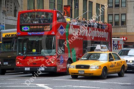 Tourists ride on a double decker bus sightseeing tour in Manhattan, New York City, New York, USA.