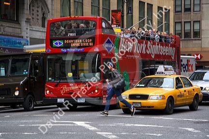 Tourists ride on a double decker bus sightseeing tour in Manhattan, New York City, New York, USA.