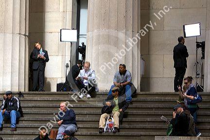 News reporters on the steps of Federal Hall located at 26 Wall Street in New York City, New York, USA.