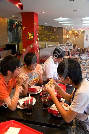 Vietnamese people eat at a Kentucky Fried Chicken restaurant inside the Diamond Plaza shopping center in downtown Ho Chi Minh City, Vietnam.
