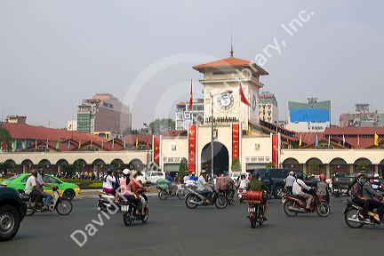 Vietnamese people ride motorbikes in front of the Ben Thanh Market in Ho Chi Minh City, Vietnam.