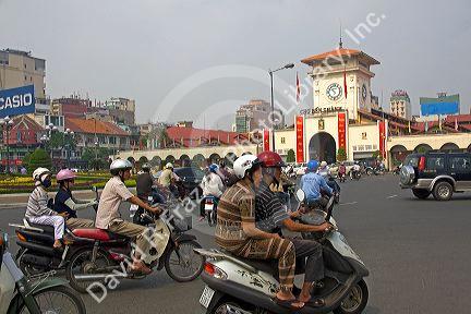 Vietnamese people ride motorbikes in front of the Ben Thanh Market in Ho Chi Minh City, Vietnam.